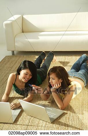Young women laying on mat using laptops View Large Photo Image Stock Photography - Young women laying on mat using laptops. Fotosearch