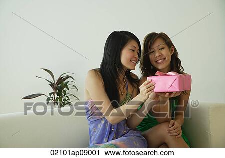 Young women with present View Large Photo Image Stock Image - Young women with present. Fotosearch