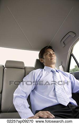Stock Image - Businessman in backseat of car. Fotosearch