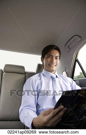 Businessman in backseat of car View Large Photo Image Stock Photo - Businessman in backseat of car. Fotosearch