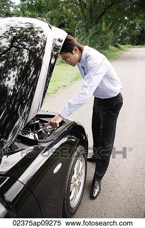 Businessman looking under hood of car View Large Photo Image Stock Photography - Businessman looking under hood of car. Fotosearch