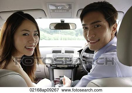 Couple driving in car, looking in back seat View Large Photo Image Stock Photo - Couple driving in car, looking in back seat. Fotosearch