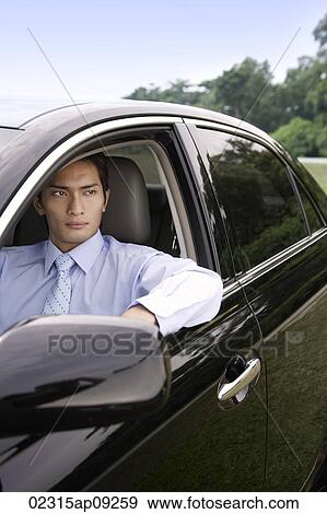 Stock Photo - Man looking out car window. Fotosearch