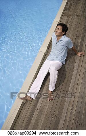 Man reclining by pool View Large Photo Image Picture - Man reclining by pool. Fotosearch