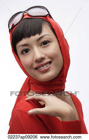 Stock Photograph - Portrait of woman wearing red sweater, scarf and sunglasses. Fotosearch