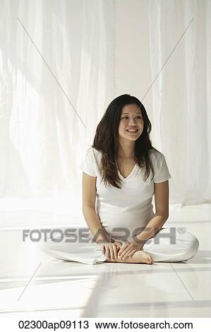 Stock Image - Pregnant woman doing yoga. Fotosearch