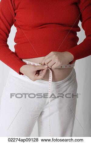 Stock Photo - Pregnant woman measuring stomach. Fotosearch