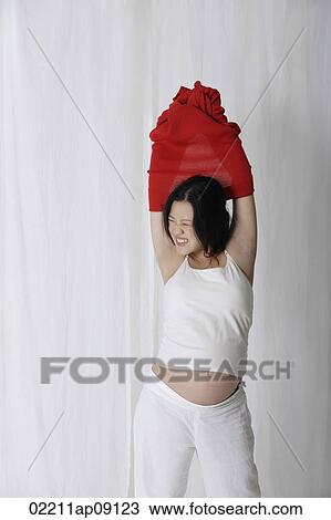 Pregnant woman putting on red sweater View Large Photo Image Stock Image - Pregnant woman putting on red sweater. Fotosearch