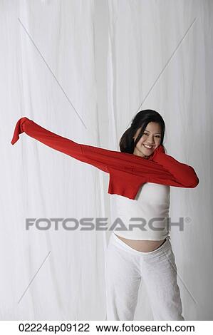Pregnant woman putting on red sweater View Large Photo Image Stock Image - Pregnant woman putting on red sweater. Fotosearch