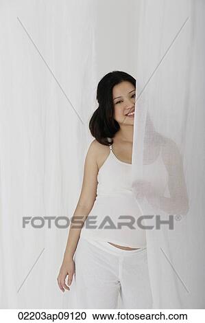 Pregnant woman standing behind curtain View Large Photo Image Stock Image - Pregnant woman standing behind curtain. Fotosearch
