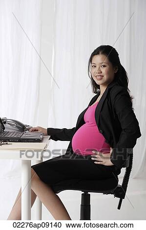 Profile of pregnant businesswoman at desk View Large Photo Image Stock Image - Profile of pregnant businesswoman at desk. Fotosearch