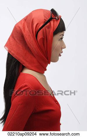 Picture - Profile of woman wearing red sweater, scarf and sunglasses. Fotosearch