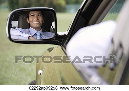 Reflection of smiling man in car rear view mirror View Large Photo Image Stock Photo - Reflection of smiling man in car rear view mirror. Fotosearch