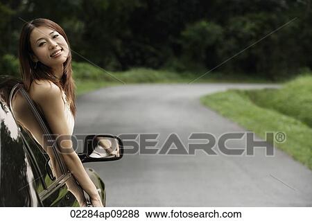 Stock Photo - Woman hanging out car window. Fotosearch