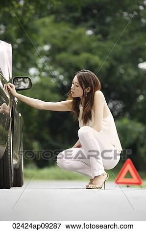 Woman inspecting car View Large Photo Image Stock Photo - Woman inspecting car. Fotosearch