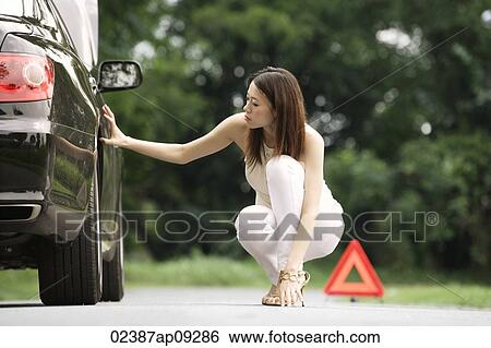 Woman inspecting car View Large Photo Image Stock Photograph - Woman inspecting car. Fotosearch