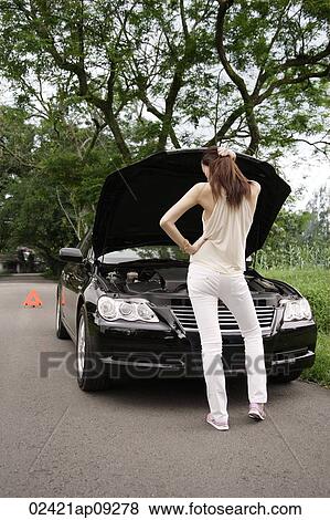 Woman looking under hood of car View Large Photo Image Stock Photo - Woman looking under hood of car. Fotosearch