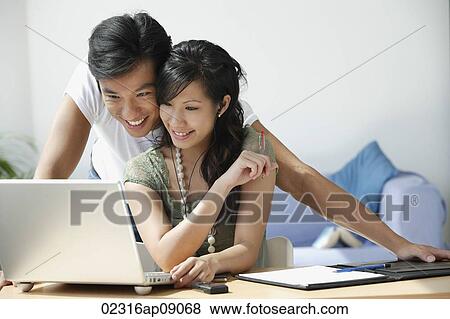 Stock Photo - Young couple working at computer. Fotosearch