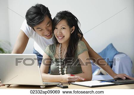 Stock Photo - Young couple working at computer. Fotosearch