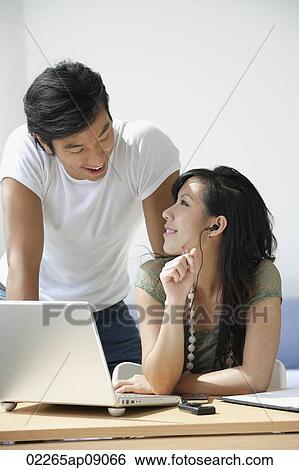 Stock Photograph - Young couple working at computer. Fotosearch