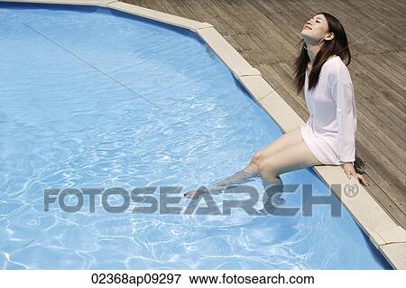 Stock Photo - Young woman having fun by pool. Fotosearch