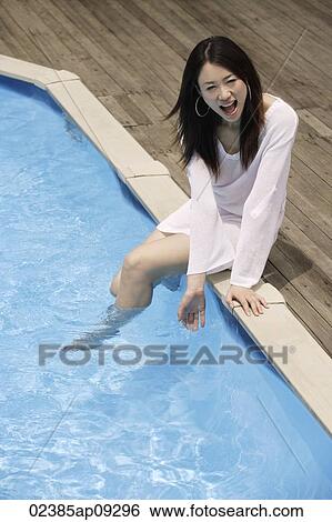 Young woman having fun by pool View Large Photo Image Stock Photograph - Young woman having fun by pool. Fotosearch