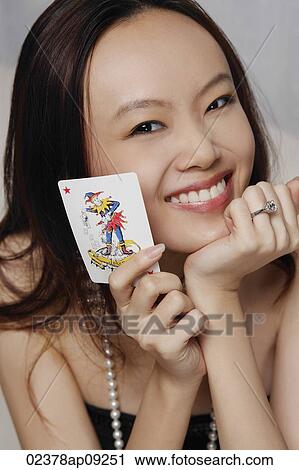 Young woman holding joker card View Large Photo Image Stock Image - Young woman holding joker card. Fotosearch
