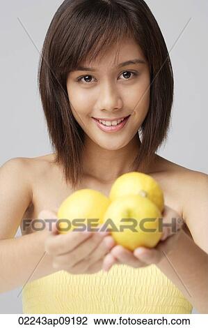 Young woman holding lemons View Large Photo Image Stock Image - Young woman holding lemons. Fotosearch