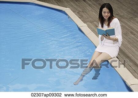 Young woman reading poolside View Large Photo Image Stock Image - Young woman reading poolside. Fotosearch