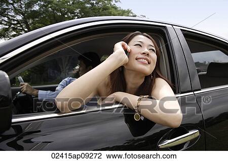 Young woman with head out window of car, on mobile phone View Large Photo Image Stock Image - Young woman with head out window of car, on mobile phone. Fotosearch