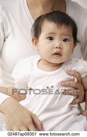 Baby girl being held on woman's lap View Large Photo Image Stock Photo - Baby girl being held on woman's lap. Fotosearch