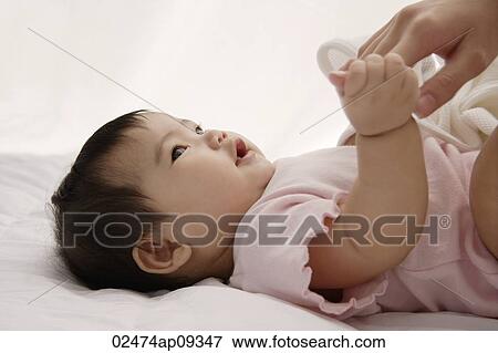 Stock Photo - baby girl holding woman's hand. Fotosearch