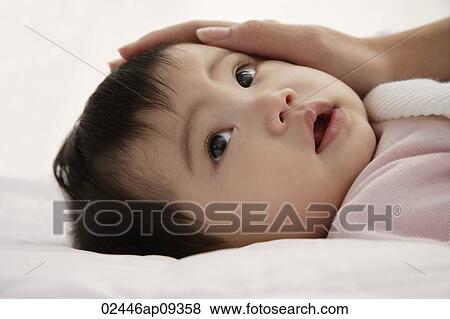 Baby girl with woman's hand caressing her face View Large Photo Image Stock Photo - Baby girl with woman's hand caressing her face. Fotosearch
