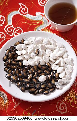 Still life of black and white melon seeds in shape of yin yang, cup of tea View Large Photo Image Stock Photograph - Still life of black and white melon seeds in shape of yin yang, cup of tea. Fotosearch