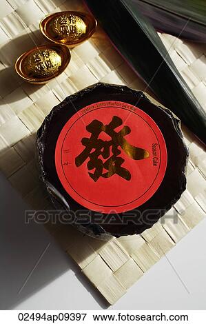 Still life of gold ingots and rice cake also known as "Nian Gao" on weaved mat. View Large Photo Image Stock Photo - Still life of gold ingots and rice cake also known as "Nian Gao" on weaved mat.. Fotosearch