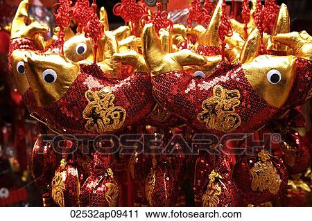 Stock Image - Still life of hanging decorations of fish with Chinese character for "fortune". Fotosearch