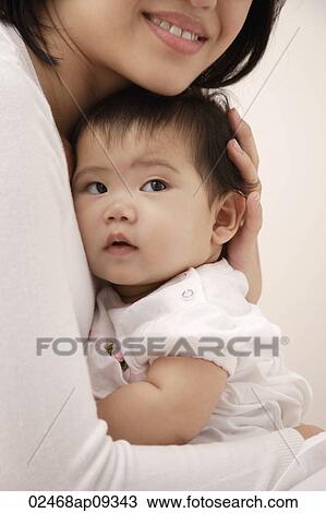 Woman holding baby girl View Large Photo Image Stock Image - Woman holding baby girl. Fotosearch