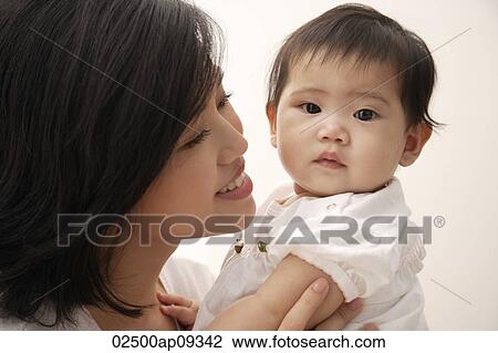 Woman holding baby girl View Large Photo Image Stock Image - Woman holding baby girl. Fotosearch