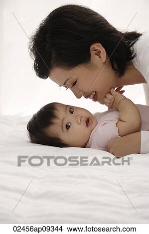 Woman with baby girl View Large Photo Image Picture - Woman with baby girl. Fotosearch