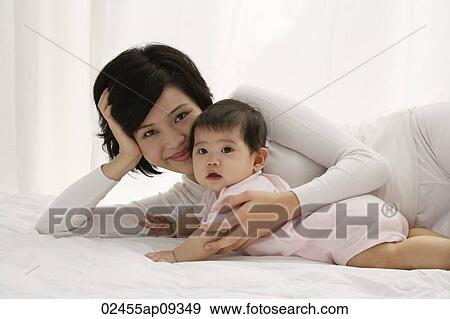 Woman with baby girl View Large Photo Image Stock Photo - Woman with baby girl. Fotosearch