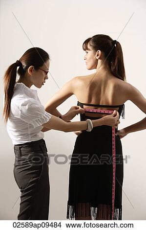 Picture - Chinese fashion designer measuring back of model's dress. Fotosearch