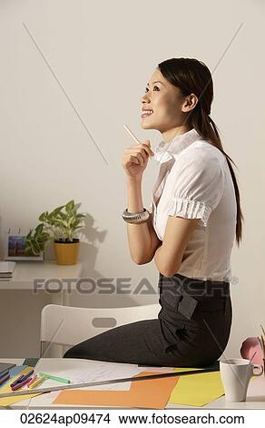 Chinese fashion designer sitting on work desk, thinking View Large Photo Image Picture - Chinese fashion designer sitting on work desk, thinking. Fotosearch