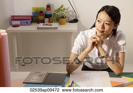 Chinese fashion designer smiling, thinking at work desk View Large Photo Image Stock Image - Chinese fashion designer smiling, thinking at work desk. Fotosearch