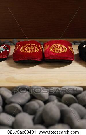 Stock Image - front view of red oriental slippers at door front. Fotosearch