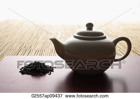 tea leaves in a pile and teapot on bamboo mat closeup View Large Photo Image Stock Photo - tea leaves in a pile and teapot on bamboo mat closeup. Fotosearch