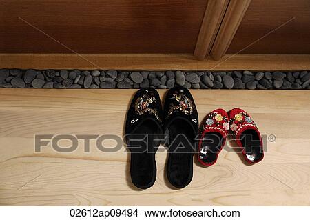 top view of red and black oriental slippers at door front View Large Photo Image Picture - top view of red and black oriental slippers at door front. Fotosearch