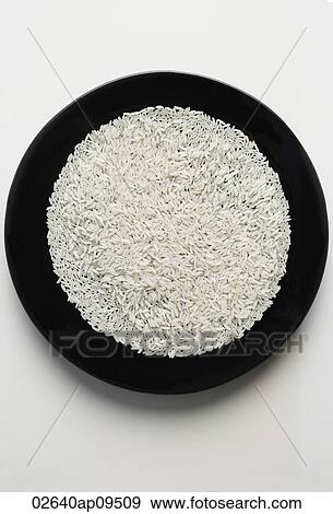 uncooked grains of rice spread out on a black plate View Large Photo Image Stock Photo - uncooked grains of rice spread out on a black plate. Fotosearch