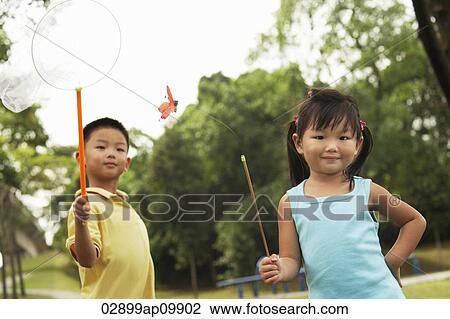 boy and girl catching butterflies View Large Photo Image Stock Image - boy and girl catching butterflies. Fotosearch