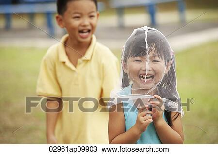 boy laughing at girl with butterfly net over her head View Large Photo Image Stock Image - boy laughing at girl with butterfly net over her head. Fotosearch
