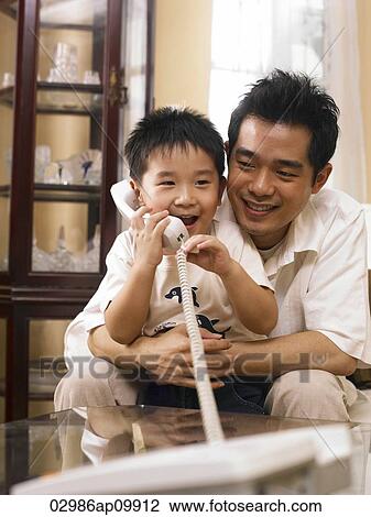 boy talking on phone while dad looks on View Large Photo Image Stock Image - boy talking on phone while dad looks on. Fotosearch